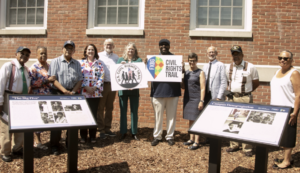 A group poses during the unveiling of two of five markers on the University of Mary Washington campus that are part of the Fredericksburg Civil Rights Trail. Pictured from left to right are: John White, Eunice Haigler, Frank White, Fredericksburg Mayor Kerry Devine, UMW Professor of Geography Steve Hanna, City of Fredericksburg Tourism Stadium and Sales Manager Victoria Matthews, UMW James Farmer Multicultural Center Assistant Director Chris Williams, UMW Professor of Historic Preservation Christine Henry, UMW President Troy Paino, Sherman White and Kaye Savage, Mary Washington's first Black residential student. Photo by Karen Pearlman.